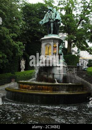 BRUXELLES, BELGIQUE - 28 juillet 2012 : statue d'une sculpture de figure humaine en bronze, sur un piédestal, dans un jardin public ou un parc avec fontaines dans le ci Banque D'Images