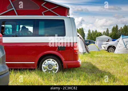 Saint-Pétersbourg, Russie - 22 juillet 2019 : Volkswagen Multivan California Ocean (transporteur T6), de couleur rouge et blanc. Garés sur le terrain de camping. Vue de moitié Banque D'Images