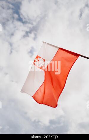 Gros plan vertical du drapeau de la Pologne avec le ciel en arrière-plan Banque D'Images