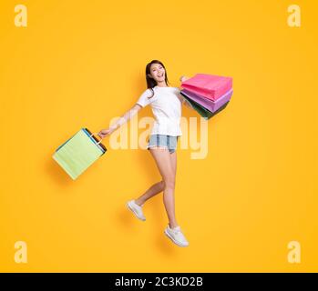 bonne jeune femme tenant avec des sacs de shopping et de saut Banque D'Images