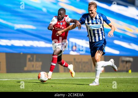 Brighton. 21 juin 2020. Nicolas Pepe (L) d'Arsenal rivalise avec Dan Burn de Brighton et Hove Albion lors du match de la Premier League entre Brighton et Hove Albion et Arsenal FC au stade communautaire American Express de Brighton, en Grande-Bretagne, le 20 juin 2020. Crédit: Xinhua/Alay Live News Banque D'Images