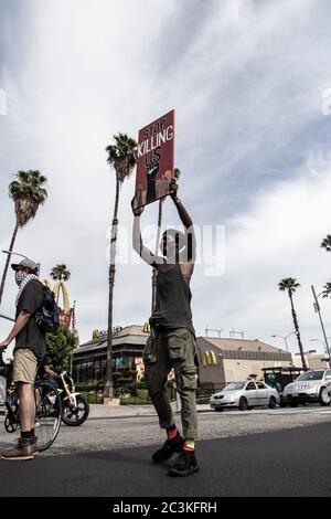 Un homme tient un panneau lisant « Stop Killing US » lors d'une marche de protestation BLM à Hollywood, Los Angeles, CA, en 2020. Banque D'Images