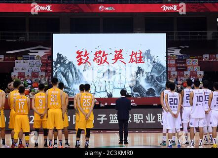 (200621) -- BEIJING, 21 juin 2020 (Xinhua) -- Les joueurs rendent un hommage silencieux aux martyrs morts dans la lutte contre la nouvelle maladie du coronavirus (COVID-19) avant le premier match après la reprise de la ligue de l'Association chinoise de basket-ball (CBA) de 2019/20 entre Nanjing Monkey Kings et Zhejiang Lions à Qingdao, dans la province de Shandong en Chine orientale, le 20 juin 2020. La saison CBA, qui a été interrompue le 1er février en raison de la pandémie COVID-19, a repris le 20 juin. Les autres matchs seront joués derrière des portes fermées dans un format de championnat à Qingdao et Dongguan. (Xinhua/Li Zihen Banque D'Images