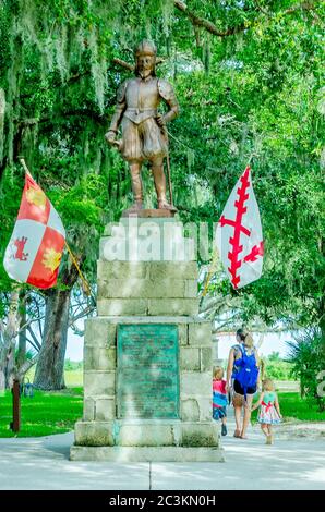 Une mère et des enfants marchent devant une statue de bronze de Ponce de Leon au parc archéologique de la Fontaine de jeunesse de Ponce de Leon à St. Augustine, Floride. Banque D'Images