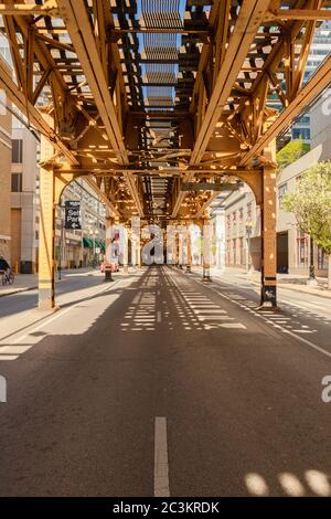 Photo verticale du pont monorail au-dessus d'une rue capturée lors d'une journée ensoleillée à Chicago, États-Unis Banque D'Images