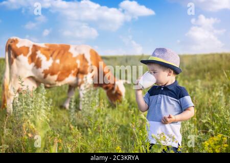 petit garçon boit du lait à l'extérieur Banque D'Images