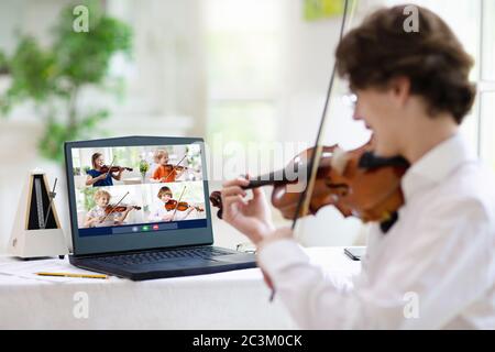 Cours de violon en ligne. Professeur et enfant jouent du violon via un ordinateur. Apprentissage à distance à la maison. Arts pour enfant. Enfants avec instrument de musique. Co. Chat vidéo Banque D'Images