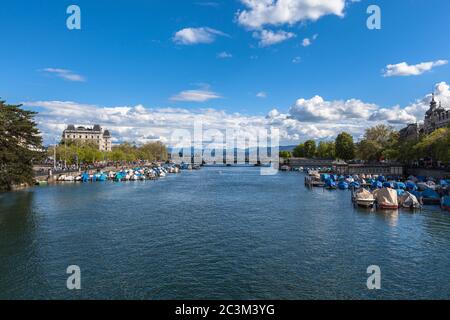 Vue panoramique sur le fleuve Limmat vers le pont Quay (Quaibruecke) et le lac de Zurich, avec la vieille ville, la chaîne de montagnes des Alpes suisses et le ciel bleu dans le backgr Banque D'Images