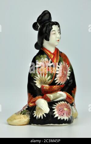 Porcelaine japonaise Meiji bijin geisha okimono dans une robe traditionnelle décorée de chrysanthèmes. Banque D'Images