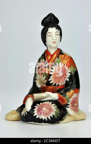 Porcelaine japonaise Meiji bijin geisha okimono dans une robe traditionnelle décorée de chrysanthèmes. Banque D'Images