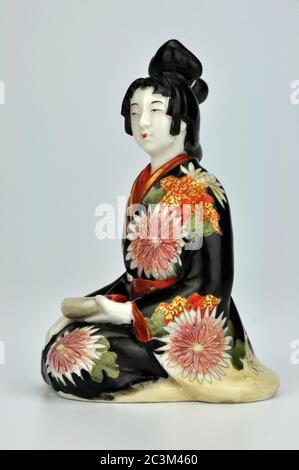 Porcelaine japonaise Meiji bijin geisha okimono dans une robe traditionnelle décorée de chrysanthèmes. Banque D'Images