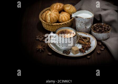 La vie de collection avec une tasse de café, des biscuits, des grains de café, de la crème et des serviettes en lin sont sur fond sombre, avec un espace de copie Banque D'Images