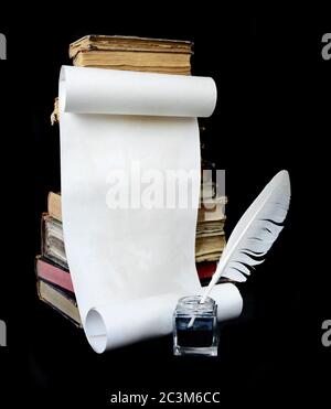 La vie encore en forme de rouleau de papier, de stylo et de pile de vieux livres sont isolés sur un fond noir Banque D'Images