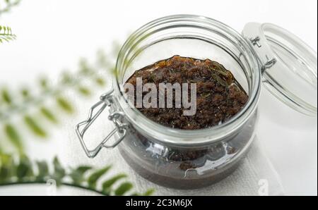 Vue de dessus d'un miel infusé aux herbes dans un pot sur une serviette blanche Banque D'Images