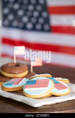 Beignets et biscuits au chocolat faits maison devant le drapeau américain pour les fêtes nationales des États-Unis, le 4 juillet Banque D'Images