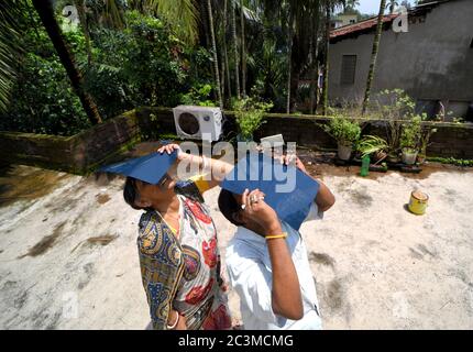 Kolkata, Inde. 21 juin 2020. Les femmes utilisent des plaques à rayons X pour observer l'éclipse solaire. L'éclipse solaire partielle de Kolkata durera environ trois heures et 31 minutes. Il a commencé à 10:46 heure locale et se terminera à 2:17 heures pendant cette période, environ 67% du Soleil sera couvert par l'ombre de la Lune . Crédit : SOPA Images Limited/Alamy Live News Banque D'Images