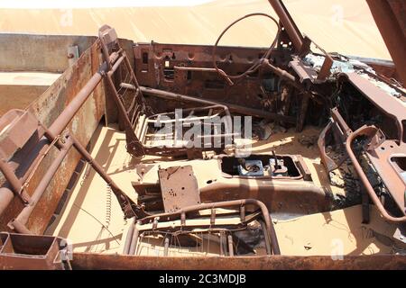 L'épave de véhicules en 4x4 (quatre roues motrices) rouillés et partiellement enfoui dans les dunes de sable du désert arabe. Le sable est lentement en train d'engloutir l'épave. Banque D'Images