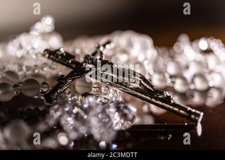 Gros plan de Jésus-Christ sur un collier en cristal avec croix brillante argentée Banque D'Images