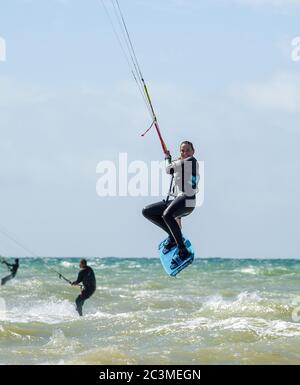 Brighton UK 21 juin 2020 - Kite Surfers Profitez de la brise parfaite et des conditions météorologiques ensoleillées à Goring by Sea près de Worthing aujourd'hui que les restrictions de verrouillage sont progressivement assouplies en Angleterre pendant la crise pandémique du coronavirus COVID-19 . La prévision est pour beaucoup plus chaud temps au cours de la semaine prochaine avec des températures atteignant 30 degrés dans certaines parties du Royaume-Uni : crédit Simon Dack / Alay Live News Banque D'Images