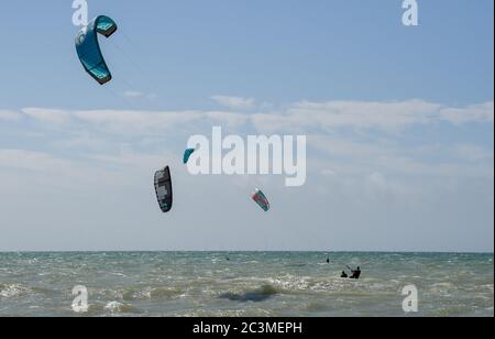 Brighton UK 21 juin 2020 - Kite Surfers Profitez de la brise parfaite et des conditions météorologiques ensoleillées à Goring by Sea près de Worthing aujourd'hui que les restrictions de verrouillage sont progressivement assouplies en Angleterre pendant la crise pandémique du coronavirus COVID-19 . La prévision est pour beaucoup plus chaud temps au cours de la semaine prochaine avec des températures atteignant 30 degrés dans certaines parties du Royaume-Uni : crédit Simon Dack / Alay Live News Banque D'Images