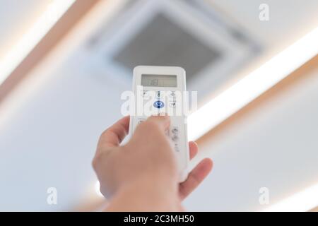 Mettez l'accent sur le bouton d'alimentation de la télécommande du climatiseur pour l'ouvrir et l'éteindre au moment de la mise en place de la salle de séminaire. Banque D'Images