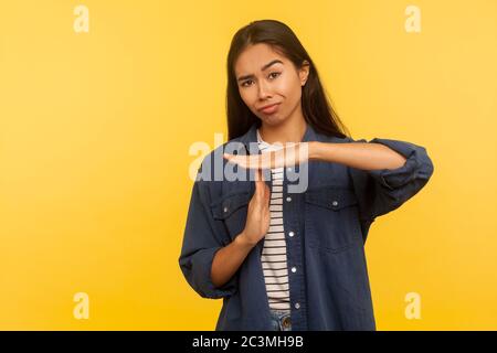 Arrêtez le contrôle, faites une pause ! Portrait d'une fille mécontenté dans une chemise en denim montrant un geste de temporisation, un avertissement de délai et demandant une pause, fixant des limites Banque D'Images