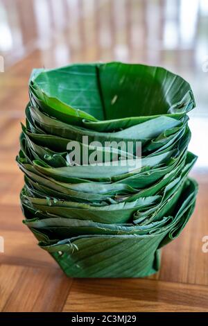 Plats locaux et traditionnels (en papier à raboiter écologique) faits à plat et bol de feuille de banane, disposés ensemble comme une tour. Banque D'Images