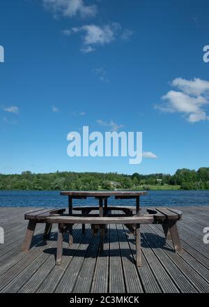 Table de pique-nique sur une plate-forme en bois au bord de la rivière. Banque D'Images