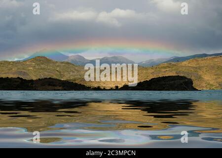 Un arc-en-ciel au-dessus de l'eau du lac Pehoe à Torres Del Paine, Patagonie, Andes, Chili. Banque D'Images