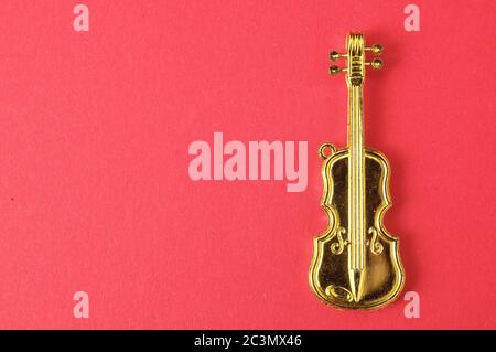 Figurine d'instrument de violon d'or sur fond coloré Banque D'Images