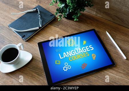 Tablette avec langues pour le texte et les icônes de cours à l'écran. Apprentissage de l'anglais en ligne. Concept d'éducation Banque D'Images