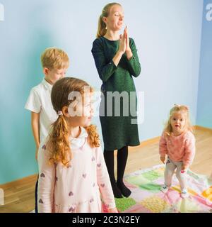 Jeux actifs en maternelle. Les enfants font des exerses avec un professeur le matin. Banque D'Images