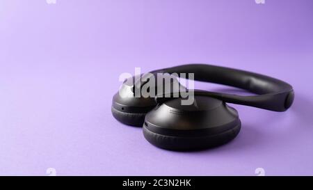 casque avec suppression du bruit et meilleur microphone. casque sans fil noir sur fond violet. Photo de haute qualité Banque D'Images