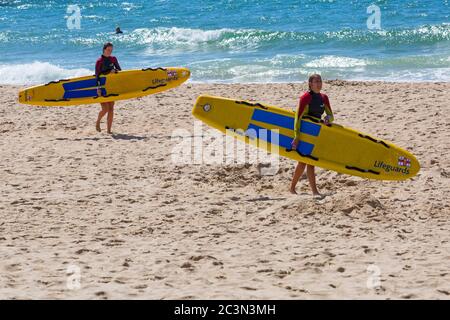 Bournemouth, Dorset, Royaume-Uni. 21 juin 2020. RNLI Lifesest de retour sur certaines plages de Bournemouth, alors que les températures s'élèveront en semaine pour une mini-vague de chaleur qui attirera la foule sur les plages. Les femmes RNLI LifeGuards tenant le surf de la vie de traîneau sur la plage. Crédit : Carolyn Jenkins/Alay Live News Banque D'Images