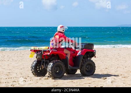 Bournemouth, Dorset, Royaume-Uni. 21 juin 2020. RNLI Lifesest de retour sur certaines plages de Bournemouth, alors que les températures s'élèveront en semaine pour une mini-vague de chaleur qui attirera la foule sur les plages. Femme RNLI Lifeguard à vélo Honda TRX quad le long de la plage. Crédit : Carolyn Jenkins/Alay Live News Banque D'Images