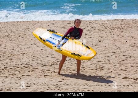 Bournemouth, Dorset, Royaume-Uni. 21 juin 2020. RNLI Lifesest de retour sur certaines plages de Bournemouth, alors que les températures s'élèveront en semaine pour une mini-vague de chaleur qui attirera la foule sur les plages. Femme RNLI Lifeguard tenant un surf de la vie de traîneau sur la plage. Crédit : Carolyn Jenkins/Alay Live News Banque D'Images