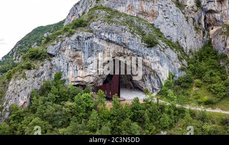 La grande entrée de la grotte de Niaux avec sa sculpture en fer, Niaux, Ariège, France Banque D'Images