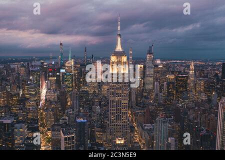 Vers septembre 2019 : vue imprenable sur l'Empire State Building la nuit à Manhattan, New York City entourée de gratte-ciel la nuit Banque D'Images