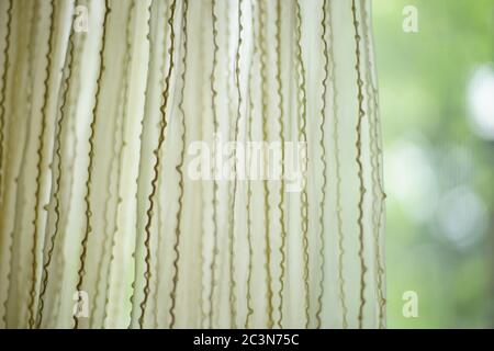 Tulle mate avec motif de filetages verticaux. Jardin vert flou en arrière-plan, vue de face Banque D'Images