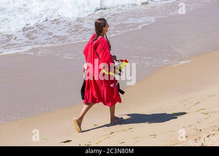 Bournemouth, Dorset, Royaume-Uni. 21 juin 2020. RNLI Lifesest de retour sur certaines plages de Bournemouth, alors que les températures s'élèveront en semaine pour une mini-vague de chaleur qui attirera la foule sur les plages. Femme RNLI Lifeguard marchant le long de la visière portante de la mer pendant la pandémie Covid-19. Crédit : Carolyn Jenkins/Alay Live News Banque D'Images