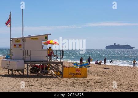 Bournemouth, Dorset, Royaume-Uni. 21 juin 2020. RNLI Lifesest de retour sur certaines plages de Bournemouth, alors que les températures s'élèveront en semaine pour une mini-vague de chaleur qui attirera la foule sur les plages. Bateau de croisière navires de croisière ancrés dans la baie en raison du coronavirus Covid 19. RNLI Lifeguard garde garde la garde au kiosque Lifeguard en service. Crédit : Carolyn Jenkins/Alay Live News Banque D'Images