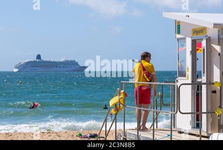 Bournemouth, Dorset, Royaume-Uni. 21 juin 2020. RNLI Lifesest de retour sur certaines plages de Bournemouth, alors que les températures s'élèveront en semaine pour une mini-vague de chaleur qui attirera la foule sur les plages. Les bateaux de croisière P&O Cruises sont ancrés dans la baie en raison du coronavirus Covid 19. RNLI Lifeguard garde garde la garde au kiosque Lifeguard en service. Crédit : Carolyn Jenkins/Alay Live News Banque D'Images