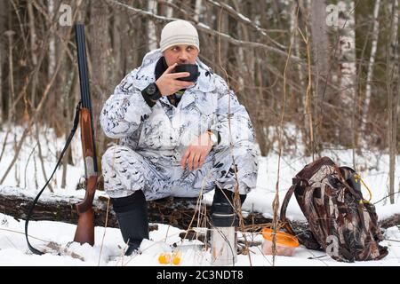 chasseur en camouflage pendant le reste de la chasse en hiver Banque D'Images