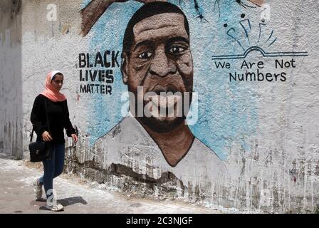 Gaza, Gaza. 21 juin 2020. Une palestinienne marche à côté d'une fresque représentant George Floyd, un homme afro-américain sans armes qui est décédé pendant qu'il était sous garde à Minneapolis, à Gaza, le dimanche 21 juin 2020. Photo par Ismael Mohamad/UPI crédit: UPI/Alay Live News Banque D'Images