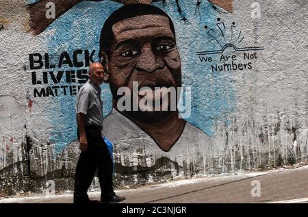 Gaza, Gaza. 21 juin 2020. Un palestinien marche à côté d'une fresque représentant George Floyd, un homme afro-américain non armé qui est décédé pendant qu'il était sous garde à vue à Minneapolis, à Gaza, le dimanche 21 juin 2020. Photo par Ismael Mohamad/UPI crédit: UPI/Alay Live News Banque D'Images