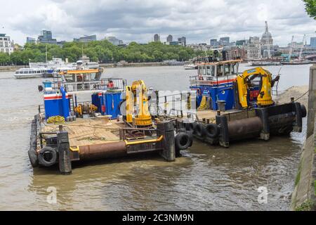 Barges flottantes le long de la Tamise avec petites grues jaunes. Londres Banque D'Images