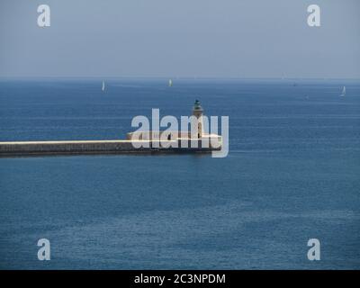 VALLETTA, MALTE - 14 juillet 2013 : le brise-lames qui protège l'entrée du Grand Port des vagues de la Valette, Malte. Phare à la Banque D'Images