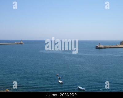 VALLETTA, MALTE - 14 juillet 2013 : le brise-lames qui protège l'entrée du Grand Port des vagues de la Valette, Malte. Phare à la Banque D'Images