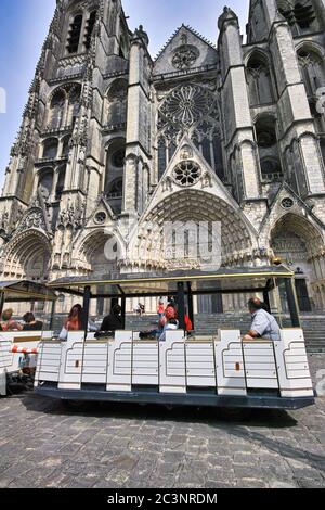 Cathédrale Saint-Étienne, Bourges, France. Petit train électrique qui s'arrête devant la façade avec des touristes qui admirent cette architecture gothique. Banque D'Images