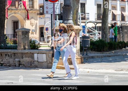 Baeza, Jaen, Espagne - 18 juin 2020 : deux femmes franchissant un passage de piétons portant un masque facial protecteur ou médical pendant l'état d'alarme et la quarantaine Banque D'Images